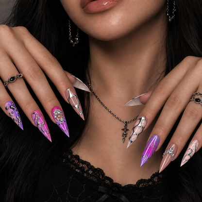 Hand model wearing Chrome Orchid Static press-on nails with vivid purple and pink abstract metallic-inspired nail art.