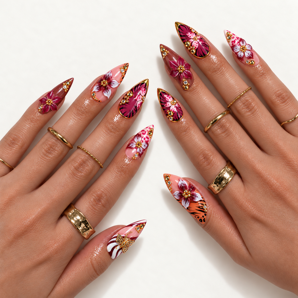 Hand model mockup showing pointed floral and animal-print nails with raised burgundy blooms, gem accents, and gold-tone details.