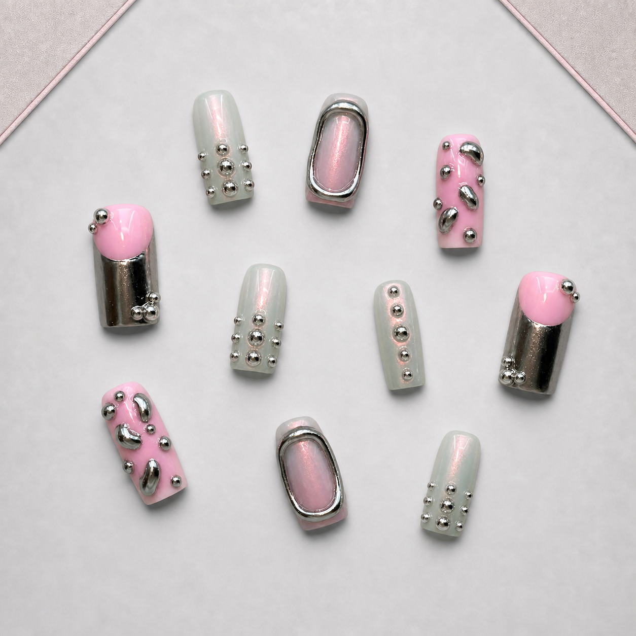Chrome Petal press-on nail set displayed on the approved walnut tray, showing pink, sage, mauve, and silver chrome details.