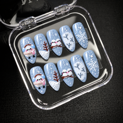 Open clear presentation case displaying ten coordinated blue winter nails in two rows of five designs.