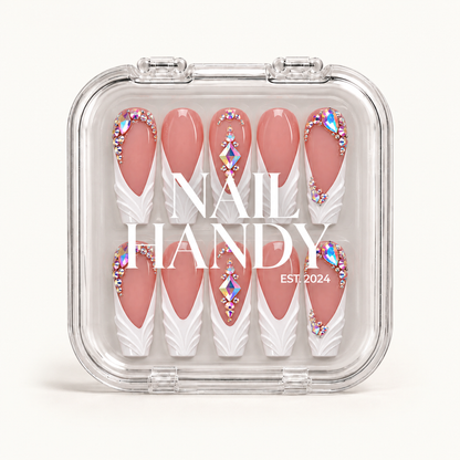 Closed clear Nail Handy case displaying ten dusty rose and white nails with sculpted tips and iridescent gem accents against a light background.