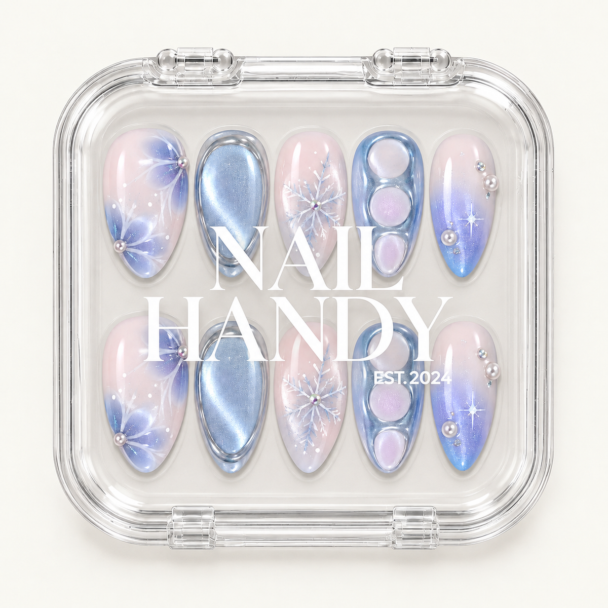 Closed clear case displaying ten pink and icy blue winter nails beneath white Nail Handy lettering on the lid.