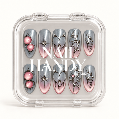 Closed clear Nail Handy case displaying ten silver-gray and blush pink nails in two rows beneath white branding.