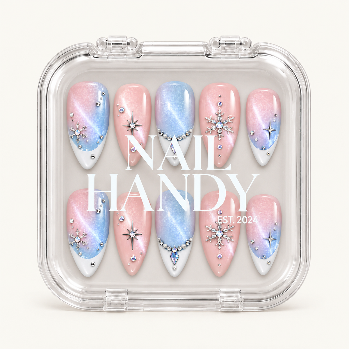 Closed clear case with white Nail Handy lettering over ten pastel pink and blue nails arranged in two rows, featuring snowflakes, starbursts, and jeweled accents.