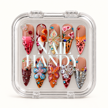 Closed clear Nail Handy case displaying ten decorated nails with raised flowers, butterfly accents, colorful gems, and silver-tone details.