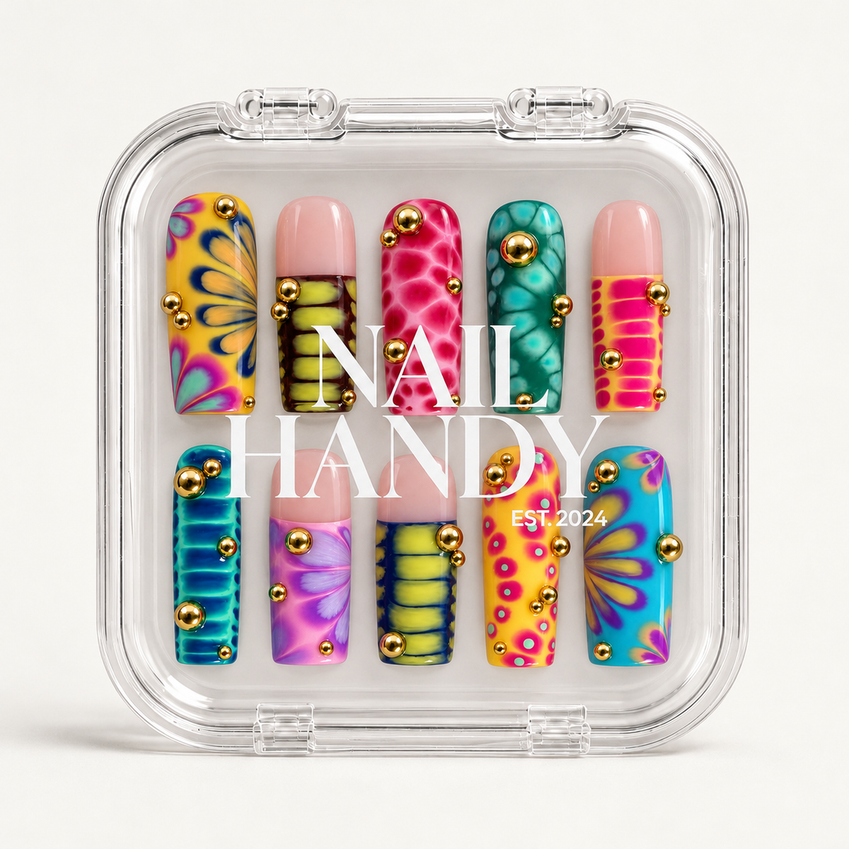 Clear closed case with white Nail Handy branding displaying ten multicolor patterned nails with blush-pink sections and gold-tone accents.
