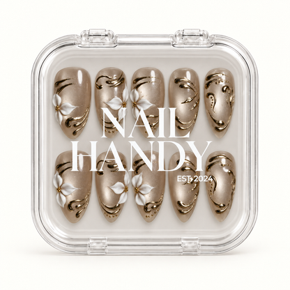 Closed clear case with white Nail Handy lettering, displaying ten coordinated taupe-greige nails with white flowers and gold-tone accents.