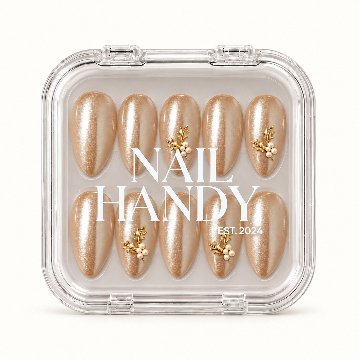 Closed clear Nail Handy case displaying ten champagne shimmer nails with gold-tone holly leaves and ivory pearl-like accents beneath white lid lettering.