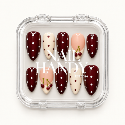 Closed clear case with white Nail Handy lettering displaying ten burgundy polka dot, ivory dotted, and blush pink cherry accent nails.