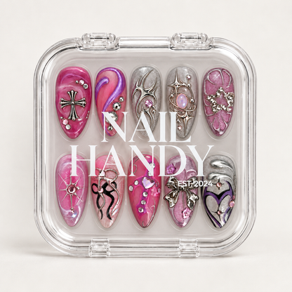 Closed clear case displaying ten coordinated decorated nails beneath white Nail Handy lettering on a light background.