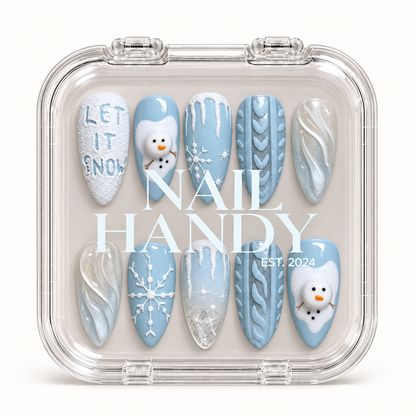 Closed clear Nail Handy case displaying ten icy blue and white winter nails with snowmen, snowflakes, sweater patterns, and pearly swirls.