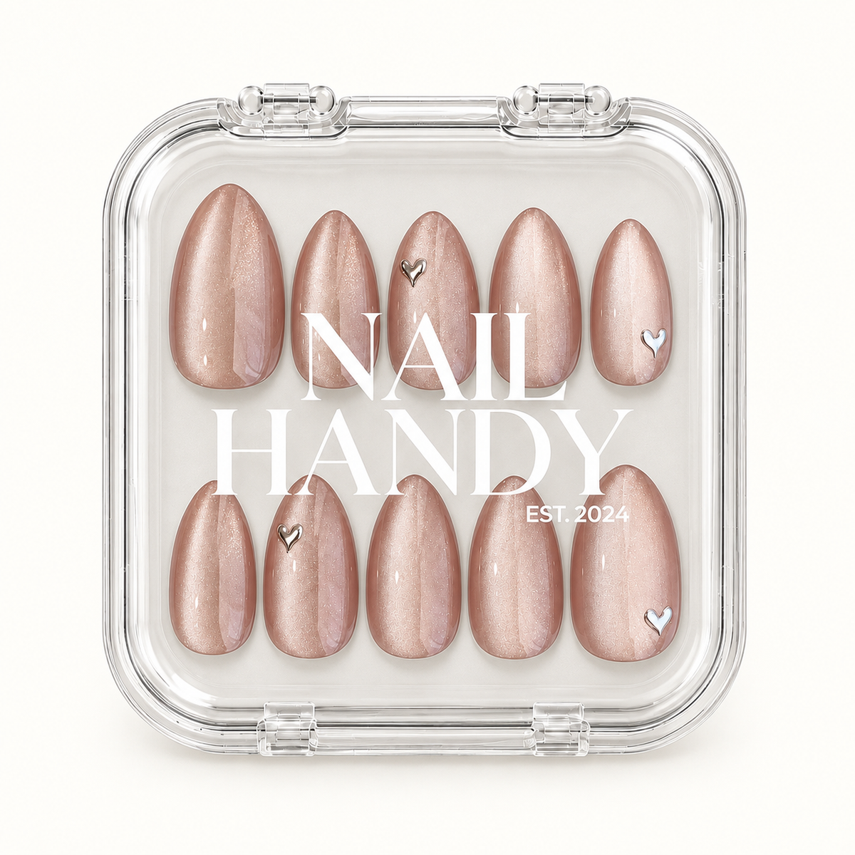 Closed clear Nail Handy case displaying ten blush-nude shimmer nails with silver-toned heart accents beneath white branding on the lid.