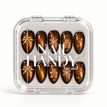 Closed clear Nail Handy case displaying ten brown and amber shimmer nails with Christmas bows, snowflakes, gingerbread figures, and stars.