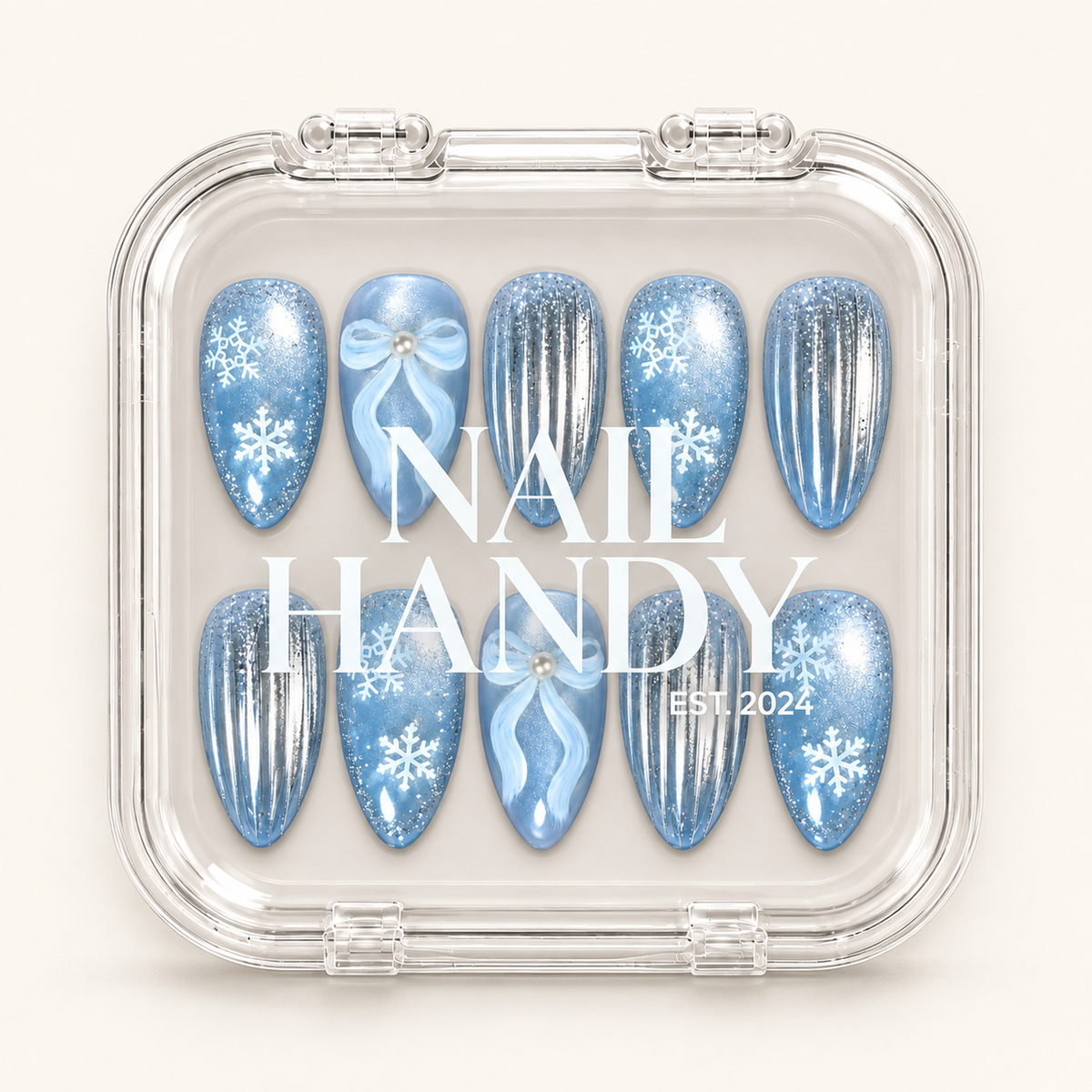 Clear Nail Handy case showing ten coordinated winter nails with icy blue snowflakes, pale blue bows, and silver-striped accents.