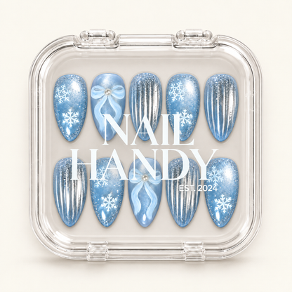Clear Nail Handy case showing ten coordinated winter nails with icy blue snowflakes, pale blue bows, and silver-striped accents.