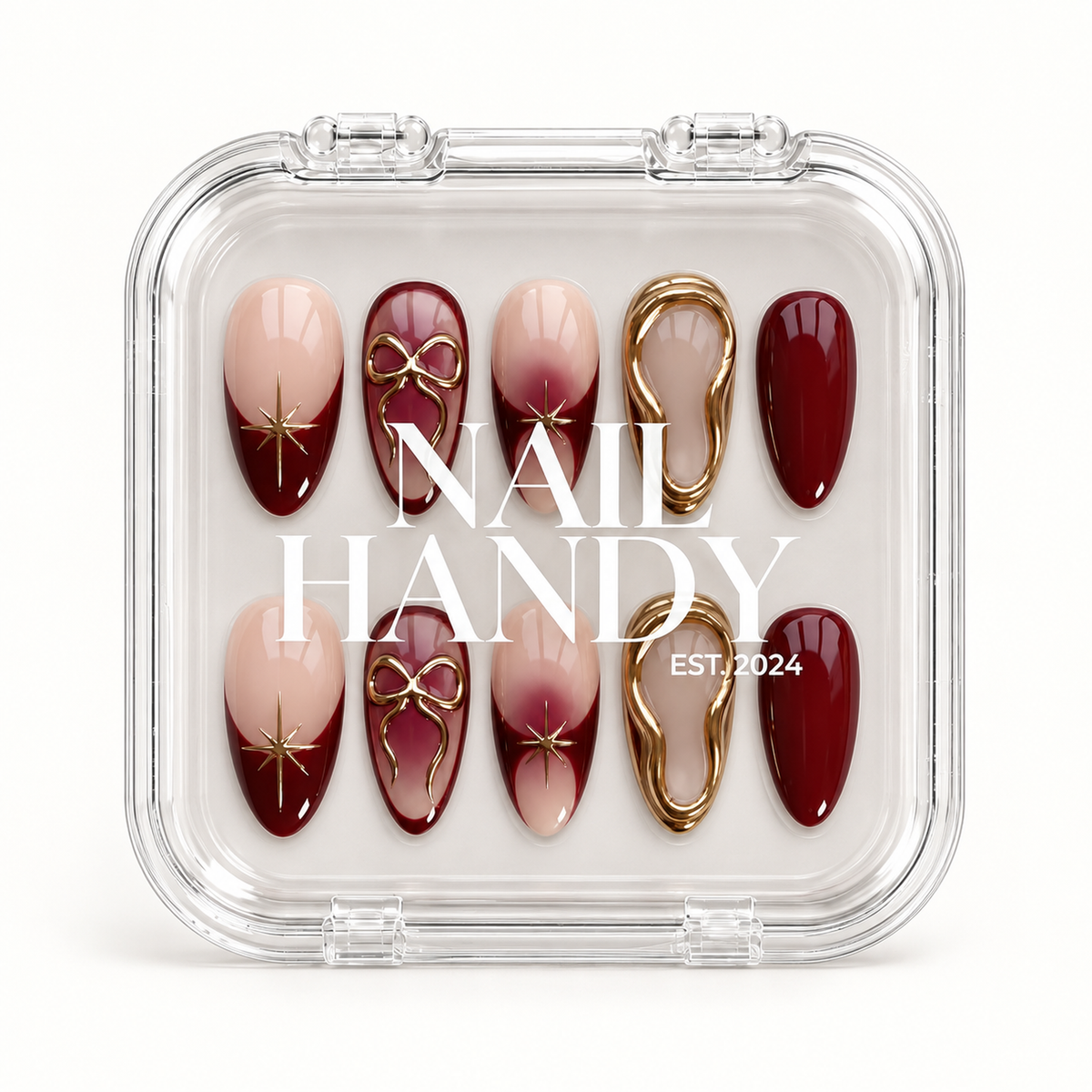 Closed clear Nail Handy case displaying ten burgundy and blush nude nails with gold bows, starbursts, and irregular gold borders.