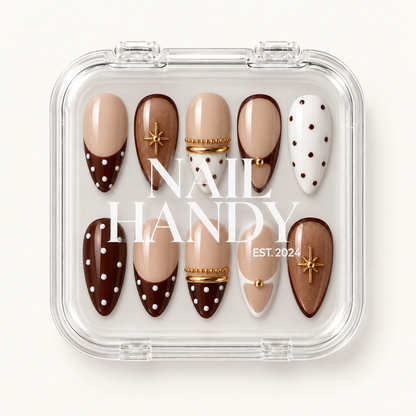 Closed clear case with white Nail Handy lettering displaying ten coordinated nude, cocoa, and cream nails with polka dots and gold accents.