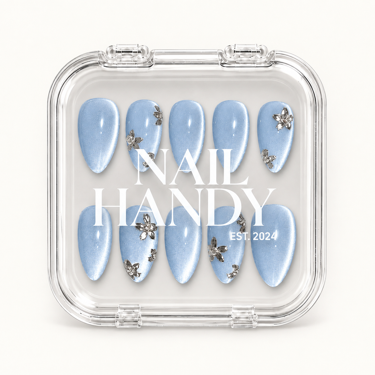 Clear display case holding ten pale blue shimmer nails, with Nail Handy lettering across the center.