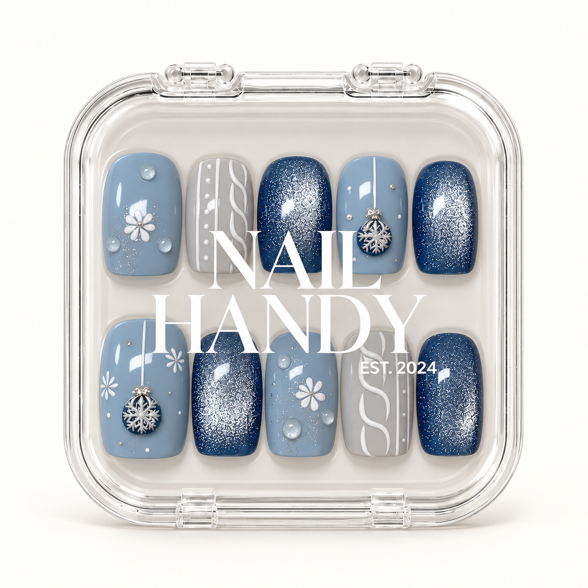 Closed clear case with white Nail Handy lettering displaying ten coordinated blue and gray winter nails with shimmer and decorative accents.