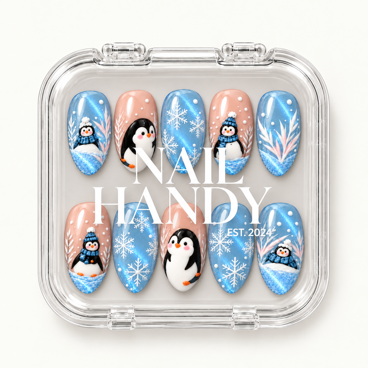 Closed clear case with white Nail Handy lettering over ten coordinated icy blue and blush pink penguin and snowflake nails.
