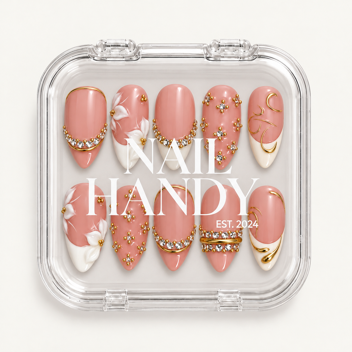 Closed clear Nail Handy case displaying ten blush-pink nails with raised white florals, clear gems, and gold-tone detailing.