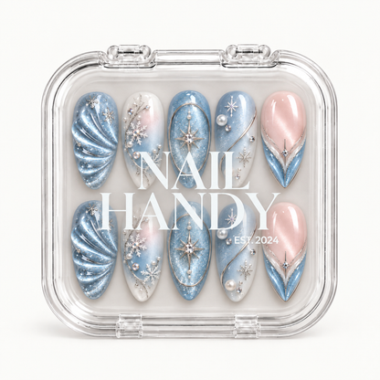 Closed clear Nail Handy case displaying ten blue, white, and blush pink winter nails in two rows beneath white lettering on the lid.