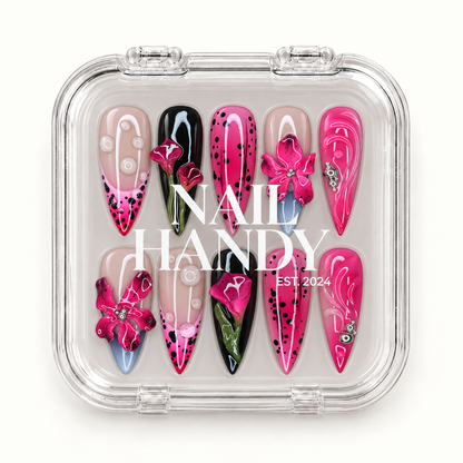 Closed clear Nail Handy case displaying ten floral nails with fuchsia blooms, black dots, pale blue tips, and silver-tone embellishments.