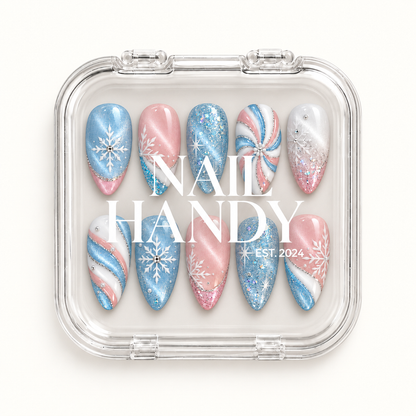 Closed clear Nail Handy case displaying ten coordinated pastel winter nails with blue glitter, pink shimmer, white snowflakes, and swirl accents.