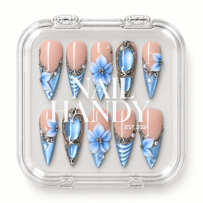 Clear Nail Handy case displaying ten coordinated pink-and-blue floral press-on nails in two rows.