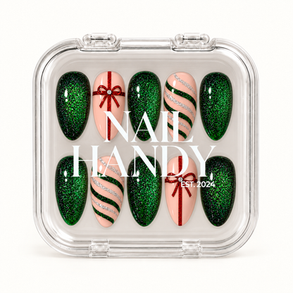 Closed clear Nail Handy case displaying ten emerald glitter and blush pink nails with red gift bows and curved glitter stripes.