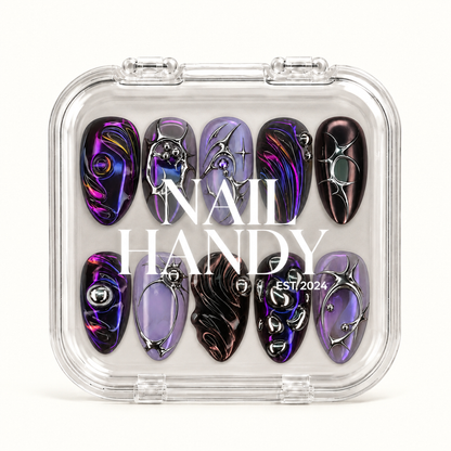 Closed clear Nail Handy case displaying ten violet, near-black, and lavender nails beneath white branding on the lid.