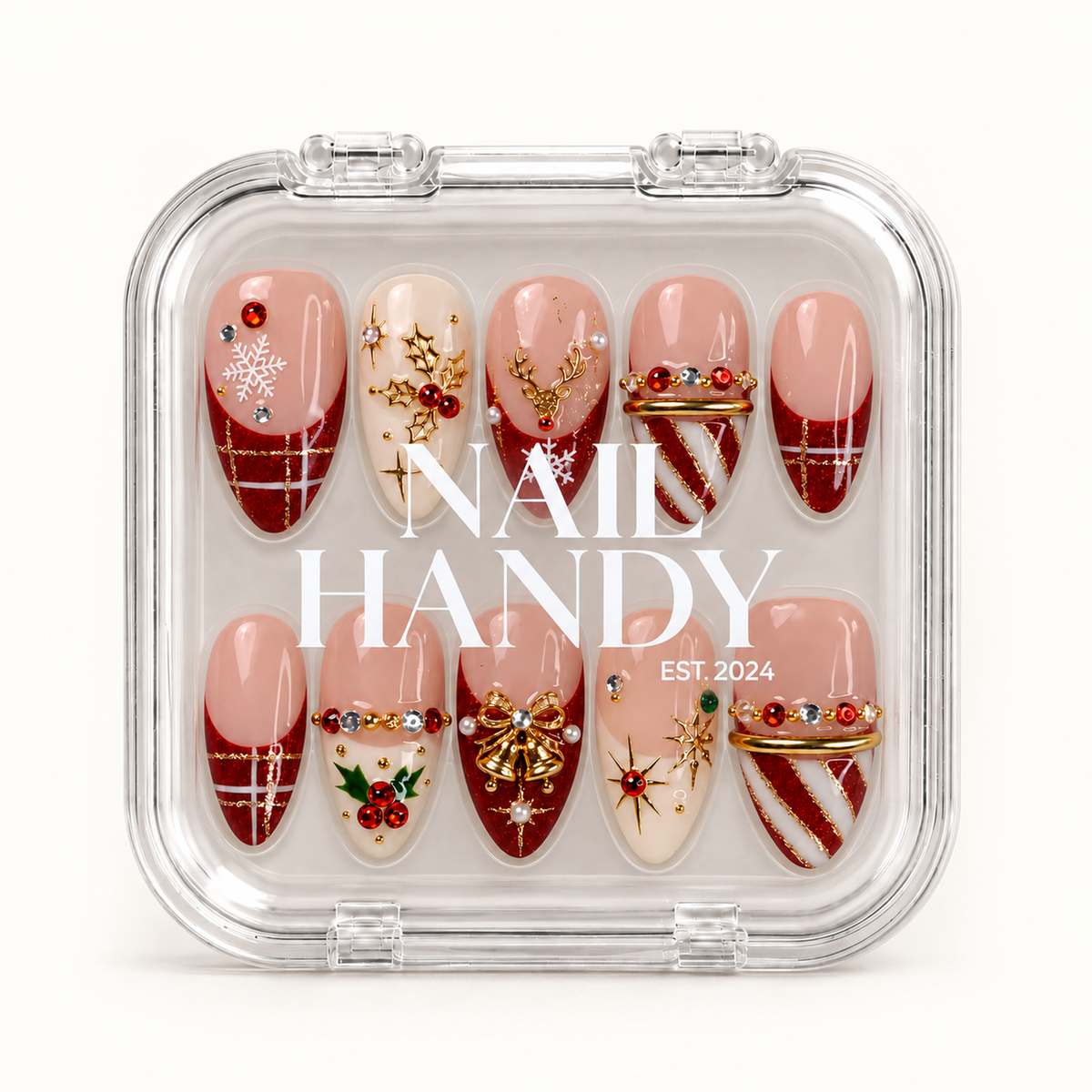 Closed clear Nail Handy case displaying ten Christmas press-on nails with ruby glitter, snowflakes, holly, gold-tone ornaments, and white lettering across the lid.