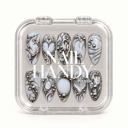 Closed clear Nail Handy case displaying ten white and silver nails in two rows beneath white lettering on the lid.