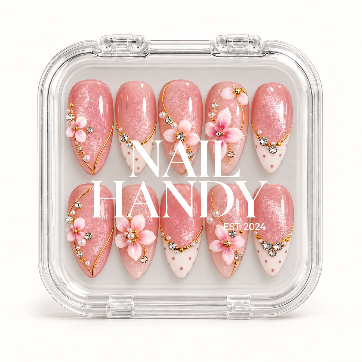 Closed clear Nail Handy case displaying ten blush pink floral nails beneath white branding, with gold-colored accents and dotted ivory tips.
