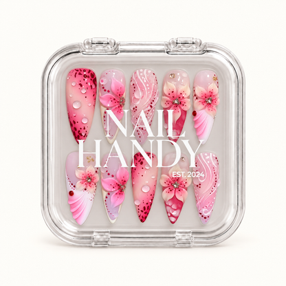 Closed clear Nail Handy case displaying ten pink floral nails in two rows, with white branding across the lid.
