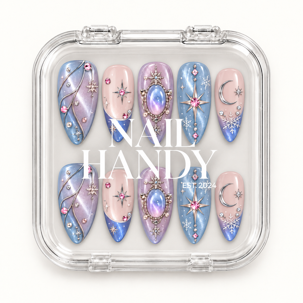 Closed clear presentation box with white lettering, showing ten blue, lilac, and blush pink nails decorated with celestial and snowflake motifs.