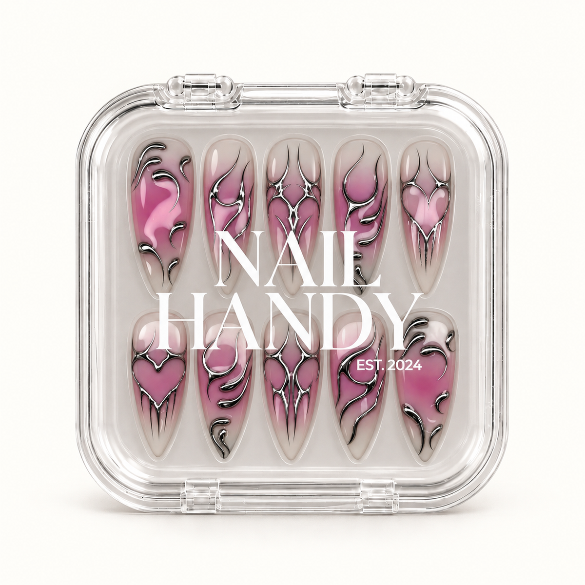 Closed clear case with white Nail Handy lettering displaying ten coordinated mauve and greige nails with silver chrome-look heart and pointed designs.