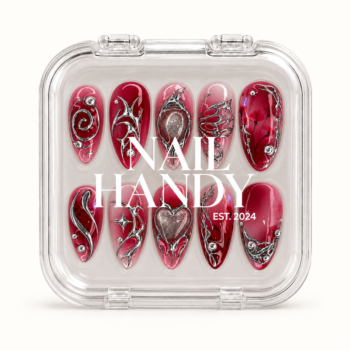Closed clear Nail Handy case displaying ten red and pink nails with silver-tone ornamental details beneath white branding on the lid.