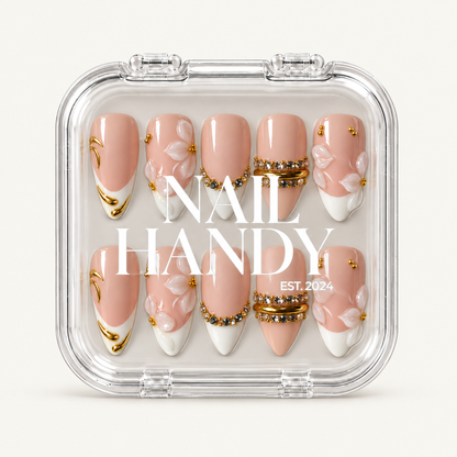 Closed clear Nail Handy case displaying ten blush and ivory nails with floral and gold-tone embellishments beneath white branding.
