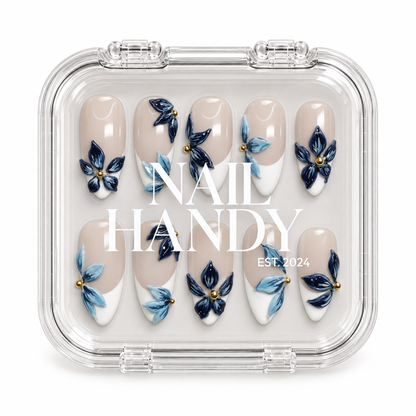 Closed clear case with white Nail Handy lettering, displaying ten blue floral French nails in two rows on a light background.