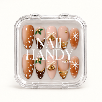 Closed clear Nail Handy case displaying ten coordinated caramel, blush, and brown Christmas nails with holly, bows, gold bells, and snowflakes.