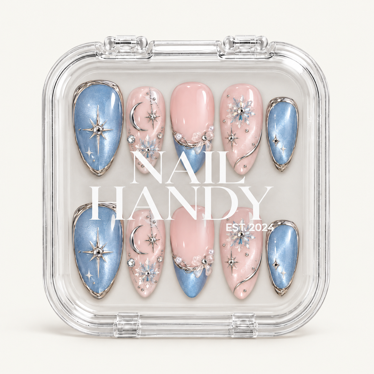 Closed clear Nail Handy case displaying ten blush pink and icy blue nails beneath white branding, with stars, moons, snowflakes, and bow accents.