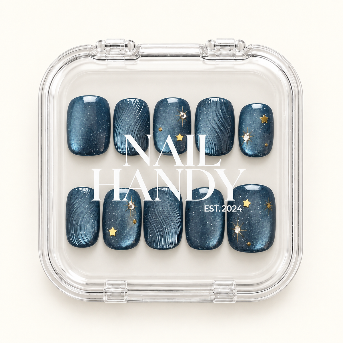 Ten navy-blue nails with gold stars and curved line details shown in a clear Nail Handy case.