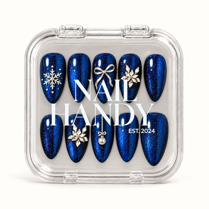 Closed clear Nail Handy case displaying ten blue shimmer nails with snowflake, bow, floral jewel-cluster, and ornament details.