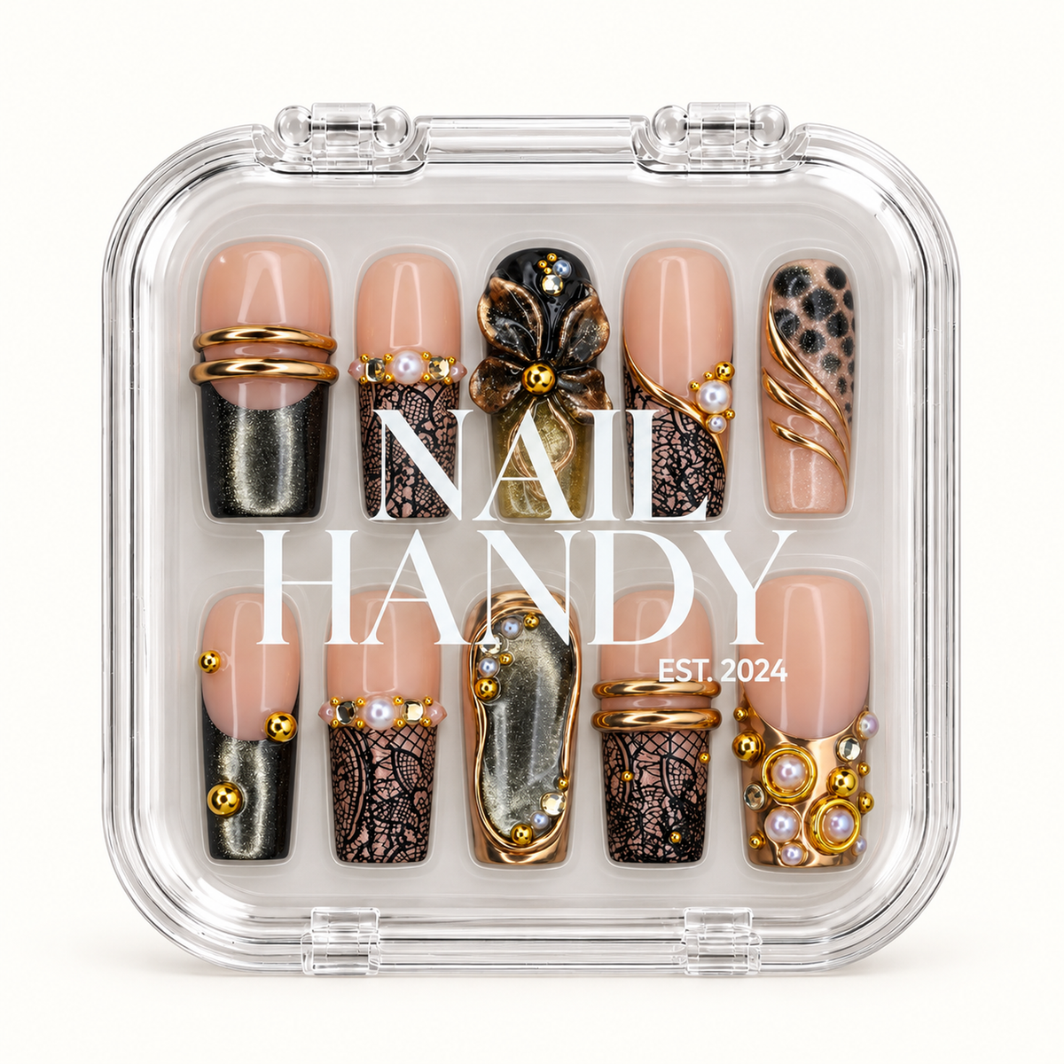 Closed clear Nail Handy case displaying ten nude pink and black nails with a raised flower, gold-tone accents, and pearl-like details beneath white lid lettering.