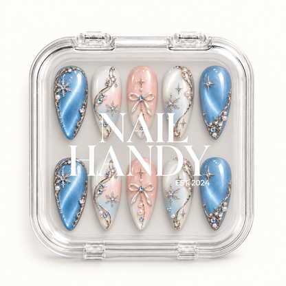 Closed clear case with white Nail Handy lettering, displaying ten coordinated winter nails with blue shimmer, pink bows, and snowflakes.