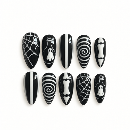 Black-and-white gothic press-on nail set with web, ghostly bottle, spiral, stripe, and bone-inspired artwork.