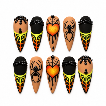 Ten pointed press-on nails in a display box with black spider webs, orange heart art, spider motifs, and neon yellow-green to orange accents.