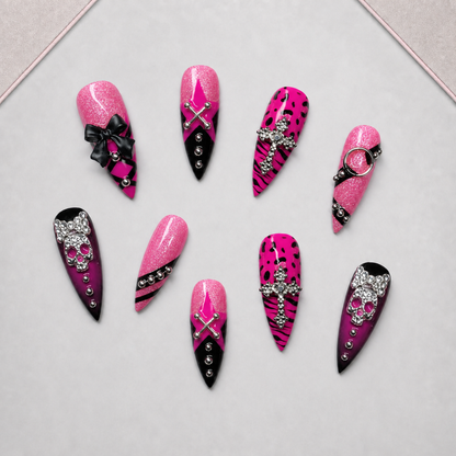 Pink Noir Charm press-on nail set arranged on an approved display tray, showing mixed pink-and-black embellished designs.