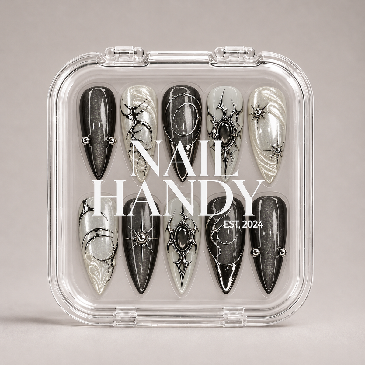 Closed clear Nail Handy case displaying ten charcoal and pearly nails in two rows, with white branding across the lid.